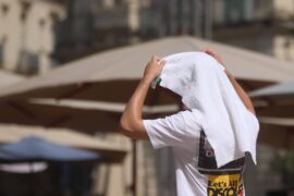 A person covers themselves with a towel as temperatures reach 38C in Montpellier, France on 19 July 2023.