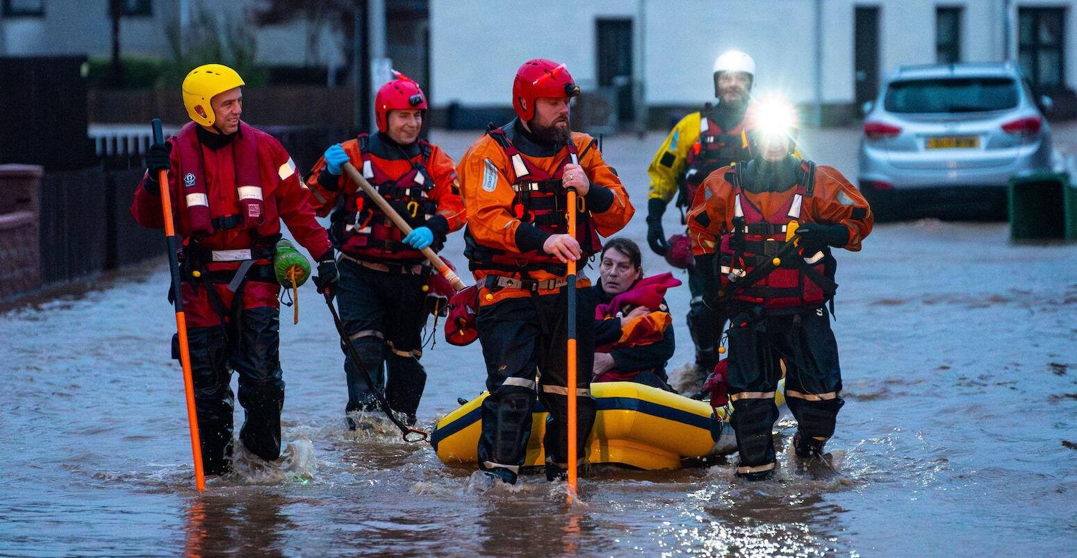 Rescue workers escort residents to safety after heavy rainfall in Brechin, Scotland on 20 October 2023.