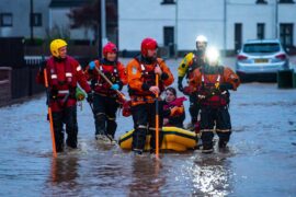 Rescue workers escort residents to safety after heavy rainfall in Brechin, Scotland on 20 October 2023.